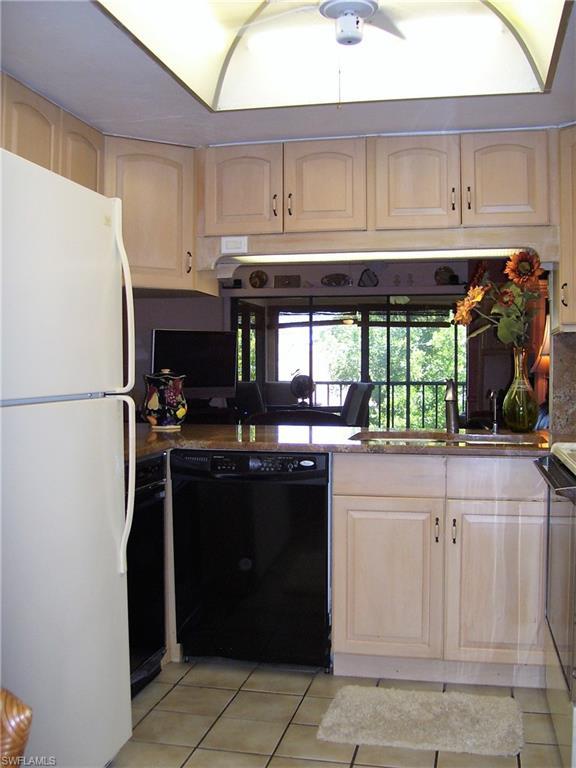 kitchen with light tile floors, white fridge, dishwasher, and sink