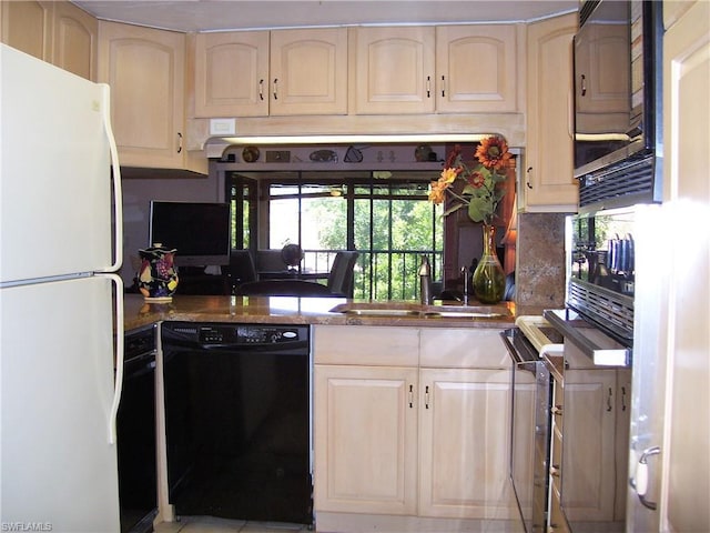 kitchen with dark stone countertops, black appliances, and sink