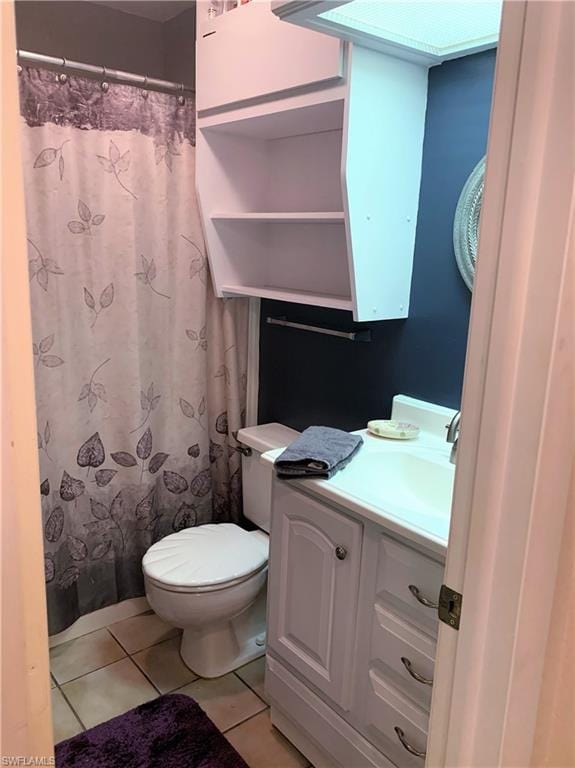 bathroom with tile flooring, large vanity, and toilet