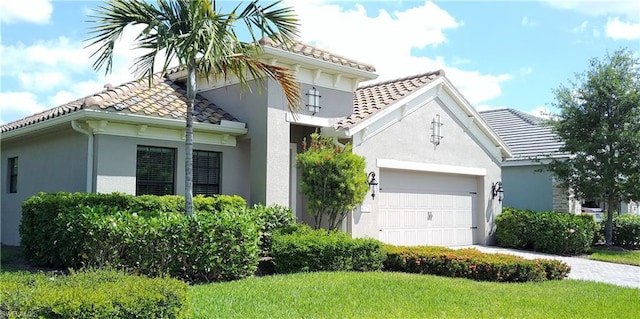 mediterranean / spanish house featuring a front lawn and a garage