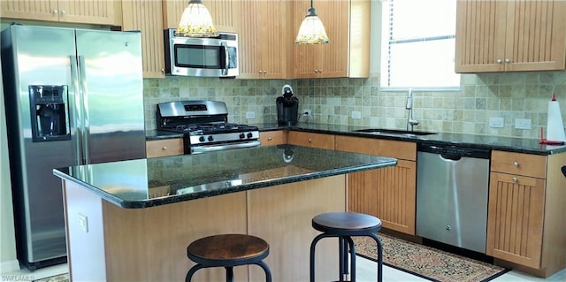 kitchen featuring appliances with stainless steel finishes, a kitchen island, and a breakfast bar