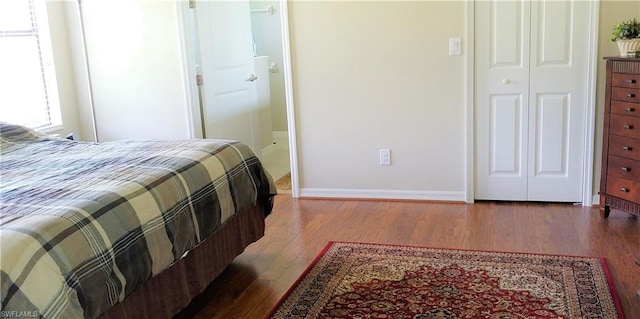 bedroom with a closet and dark hardwood / wood-style flooring