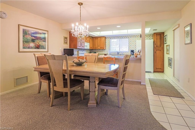 dining area featuring light tile floors and a notable chandelier