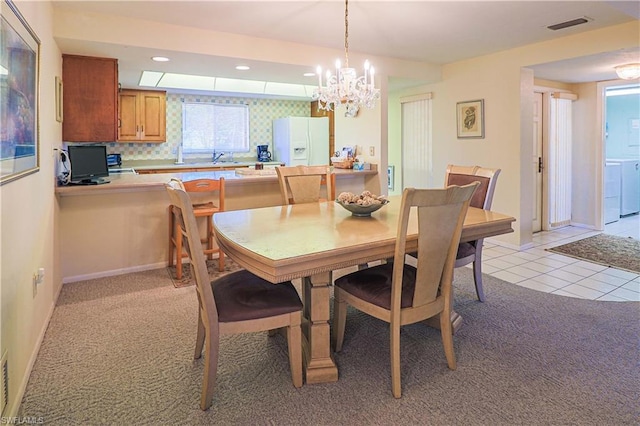 carpeted dining room featuring a chandelier