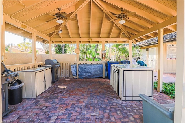 view of patio featuring a gazebo, grilling area, ceiling fan, and exterior kitchen