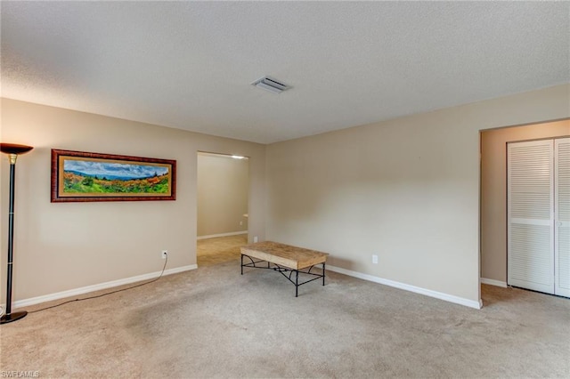 carpeted empty room with a textured ceiling