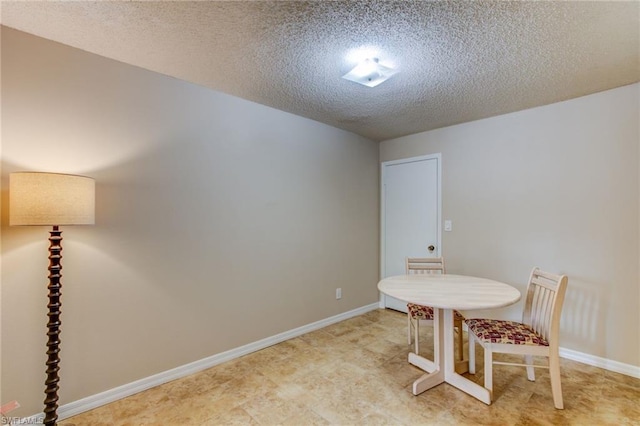 dining room with a textured ceiling and light tile flooring