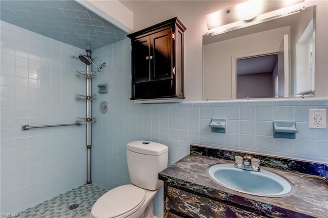 bathroom featuring toilet, vanity with extensive cabinet space, tasteful backsplash, and tile walls