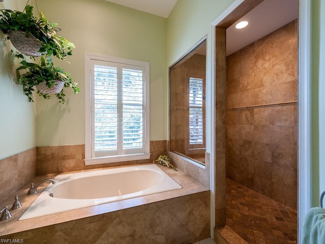 bathroom with plenty of natural light and shower with separate bathtub