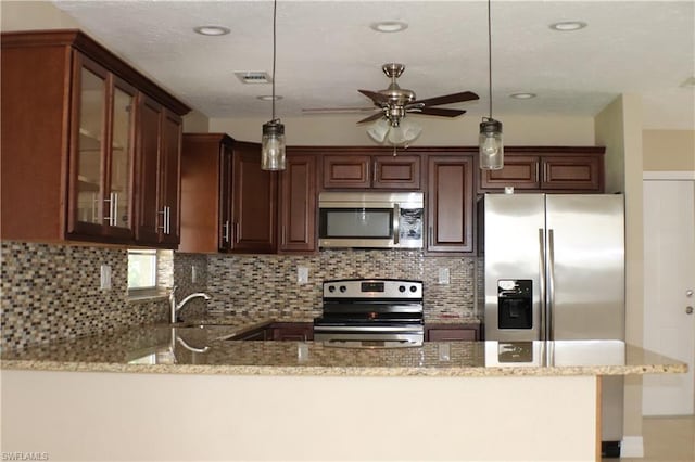 kitchen with hanging light fixtures, stainless steel appliances, ceiling fan, and sink