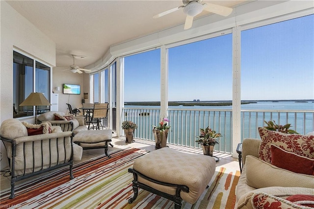 sunroom / solarium with a water view and ceiling fan