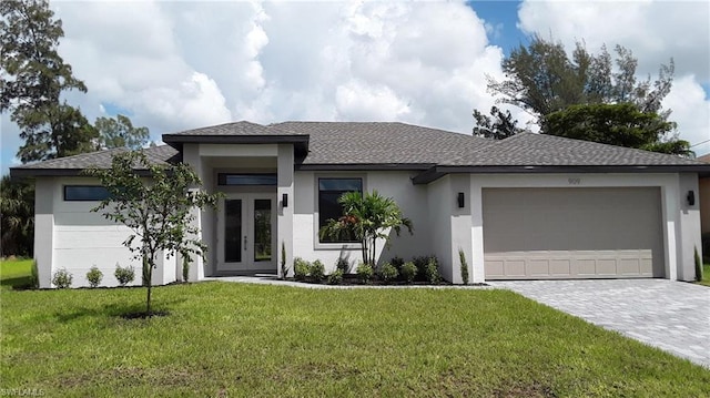 prairie-style home with french doors, a front lawn, and a garage