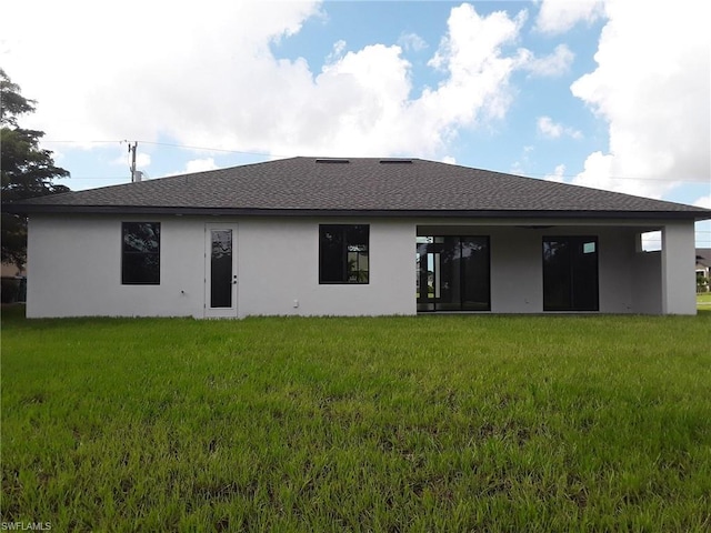 rear view of house featuring a lawn