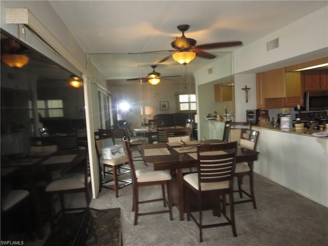 carpeted dining room with ceiling fan