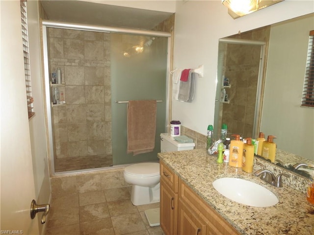 bathroom with a shower with door, tile flooring, oversized vanity, and toilet