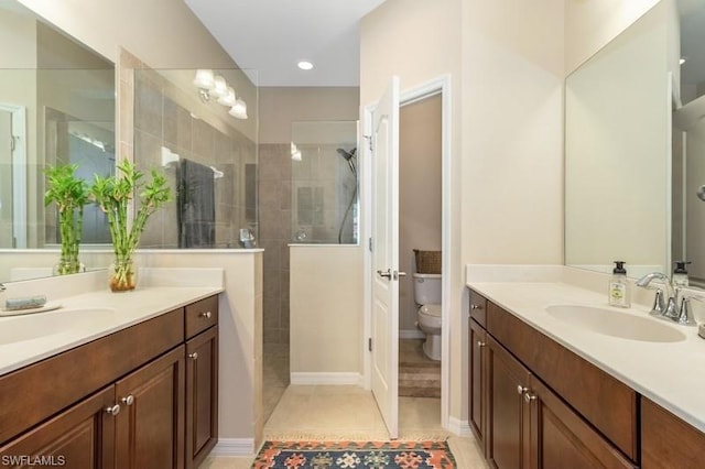 bathroom with toilet, vanity, tiled shower, and tile flooring