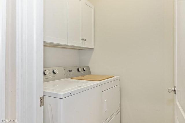 washroom with washing machine and dryer and cabinets