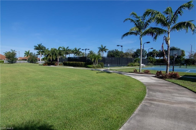 view of home's community featuring a yard and basketball court