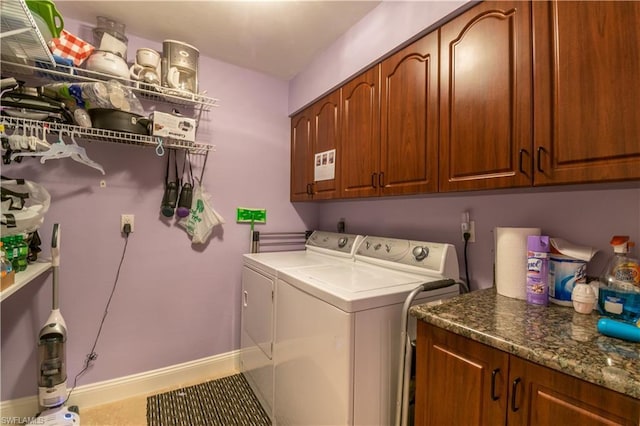 washroom featuring tile floors, washing machine and dryer, and cabinets