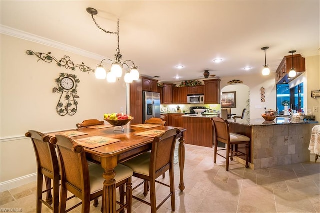 dining area featuring light tile floors, a notable chandelier, and crown molding