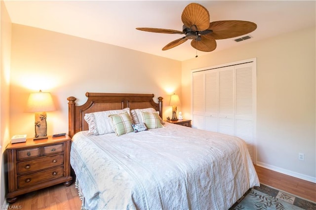 bedroom with a closet, ceiling fan, and dark hardwood / wood-style flooring