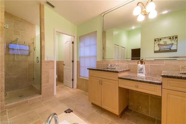 bathroom featuring large vanity, tasteful backsplash, and tile walls