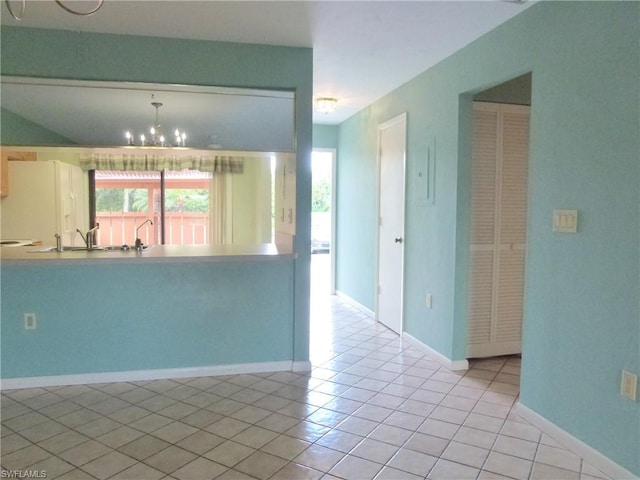 kitchen with a chandelier, light tile flooring, pendant lighting, and sink