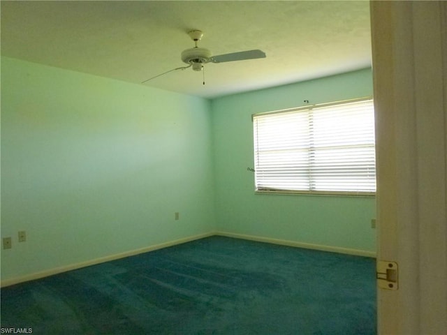 unfurnished room with ceiling fan and dark carpet