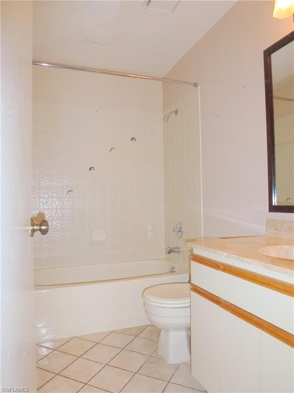 full bathroom featuring tile floors, tiled shower / bath combo, toilet, and vanity