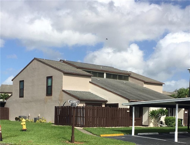 back of house featuring a lawn and central air condition unit