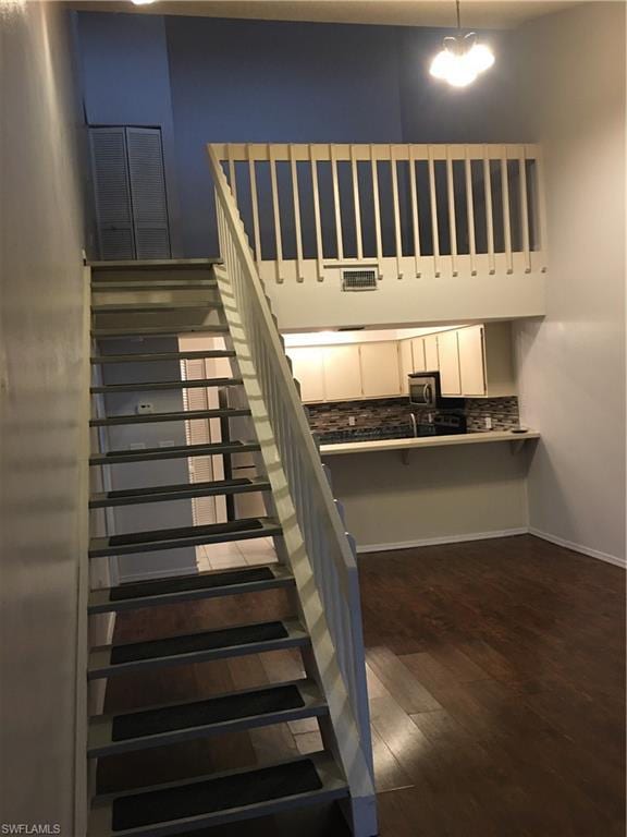 staircase with dark hardwood / wood-style flooring