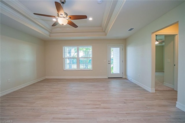 spare room featuring a raised ceiling, light hardwood / wood-style floors, and ceiling fan