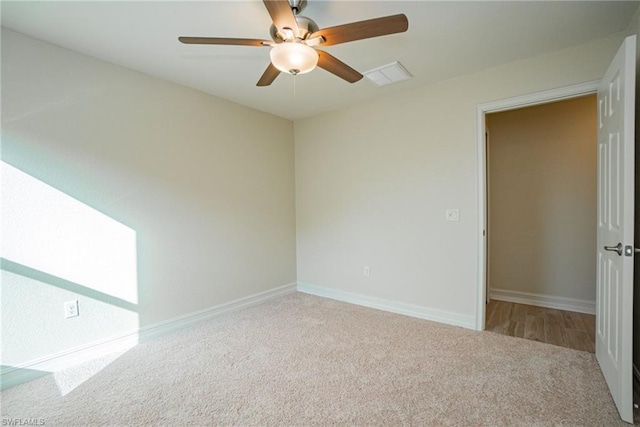 carpeted spare room featuring ceiling fan