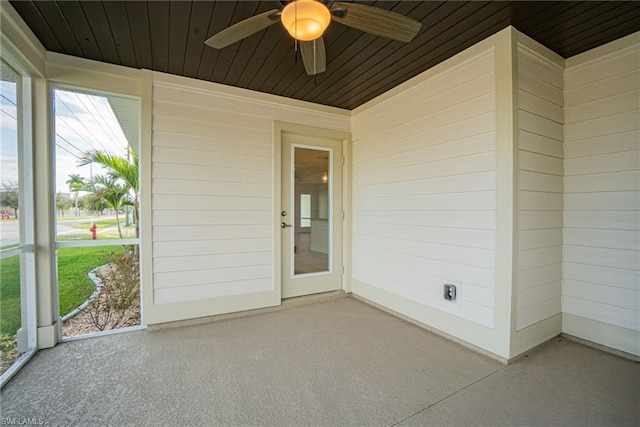 unfurnished sunroom featuring wood ceiling and ceiling fan