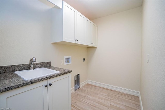 clothes washing area with hookup for an electric dryer, sink, hookup for a washing machine, cabinets, and light wood-type flooring