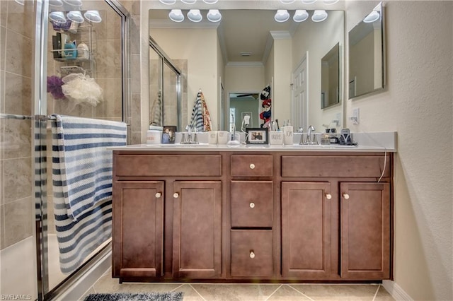 bathroom featuring crown molding, walk in shower, double vanity, and tile flooring