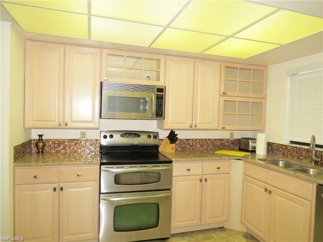 kitchen with tasteful backsplash, appliances with stainless steel finishes, and sink