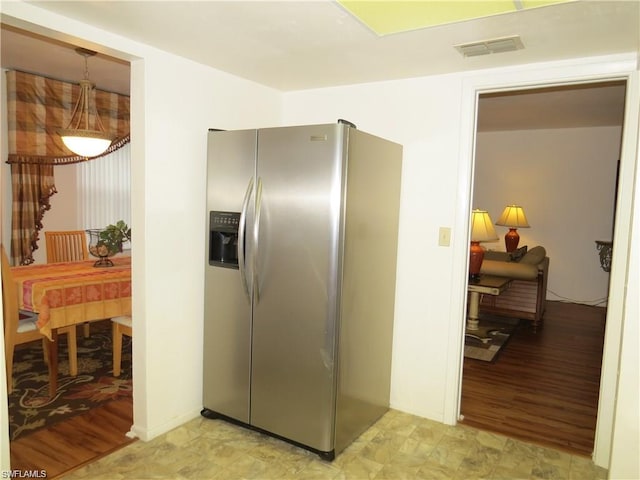 kitchen featuring stainless steel fridge and light tile floors