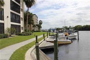 dock area with a lawn and a water view