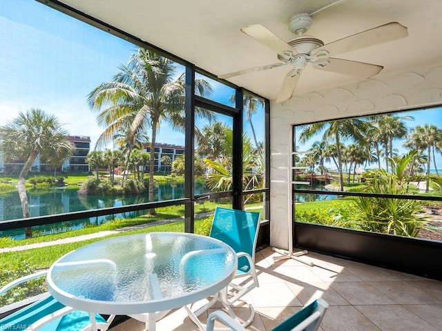 sunroom featuring a water view and ceiling fan