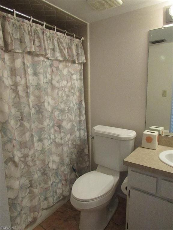 bathroom featuring toilet, tile floors, and vanity