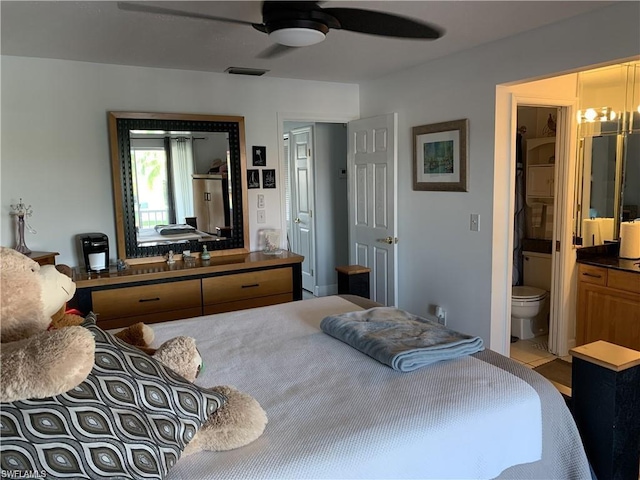 bedroom with ensuite bath and ceiling fan with notable chandelier