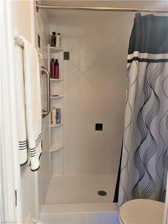 bathroom with walk in shower and toilet