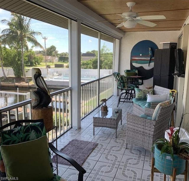 sunroom featuring ceiling fan and wood ceiling