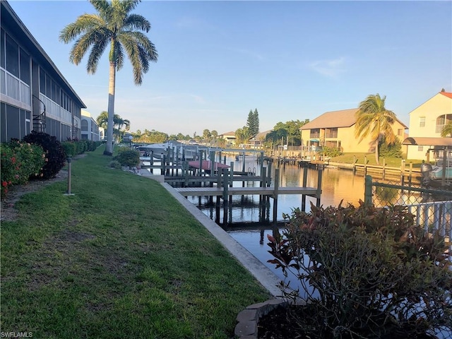 view of dock featuring a water view and a yard