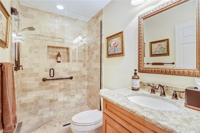 bathroom with toilet, large vanity, and walk in shower