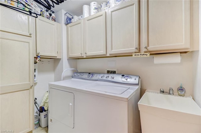 laundry room with cabinets, washer and dryer, and sink