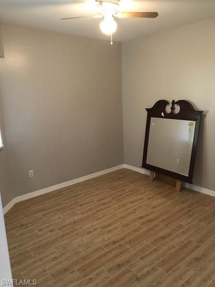 spare room with wood-type flooring and ceiling fan