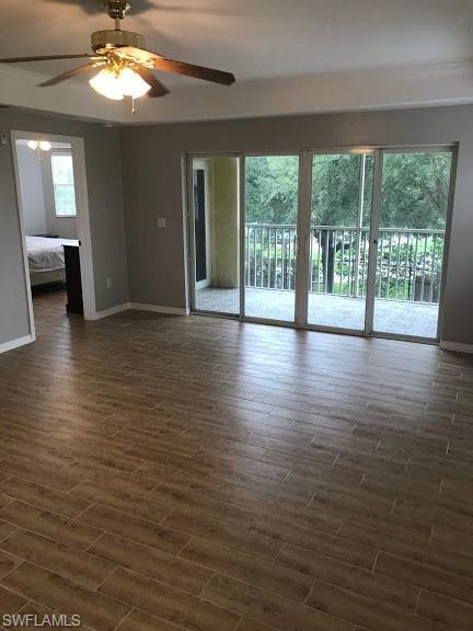 unfurnished room with dark hardwood / wood-style flooring, ceiling fan, and plenty of natural light