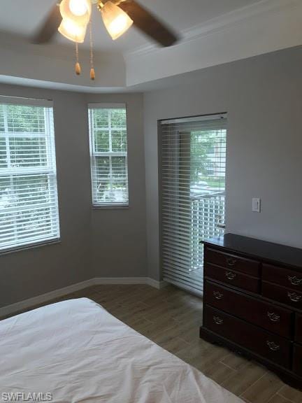 unfurnished bedroom with a raised ceiling, ceiling fan, and hardwood / wood-style flooring